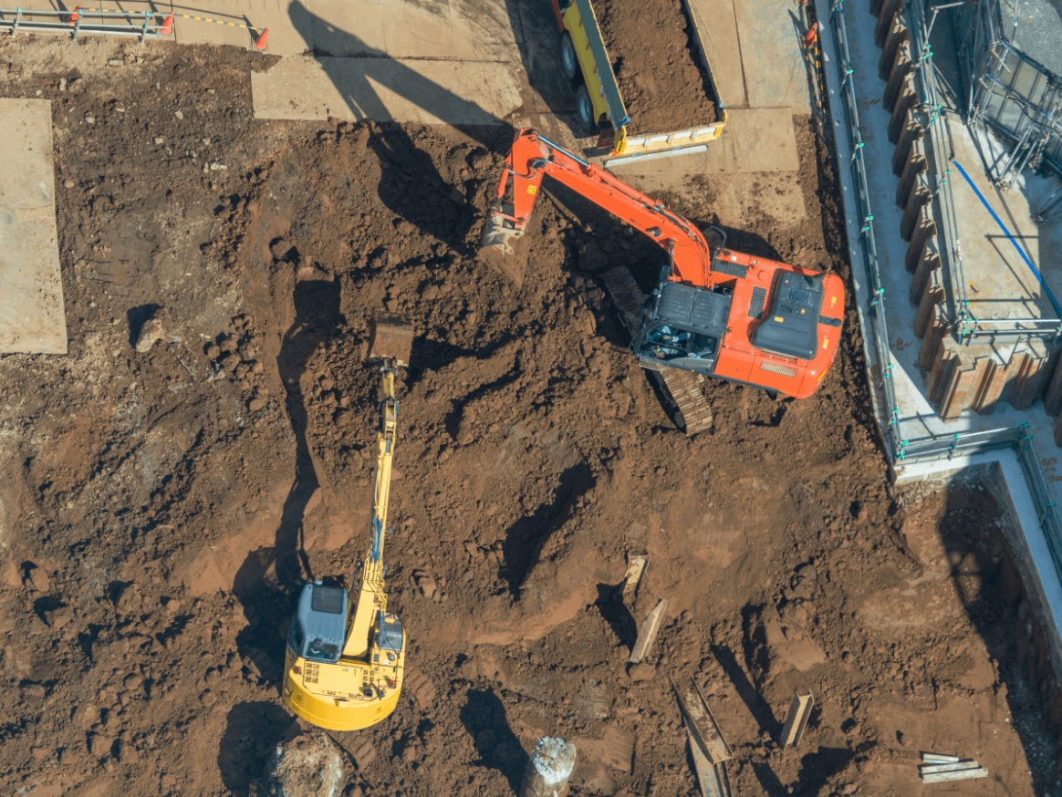 建設現場で稼働する重機による掘削作業の空撮写真