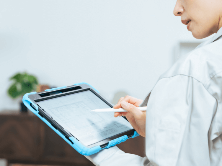 現場で図面に基づいて確認作業を行うスタッフのイメージ